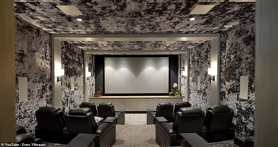 The lower level movie theater complete with 'tri-level seating, leather chairs, massive screen, rear projector, built-in speakers, (and) padded walls'