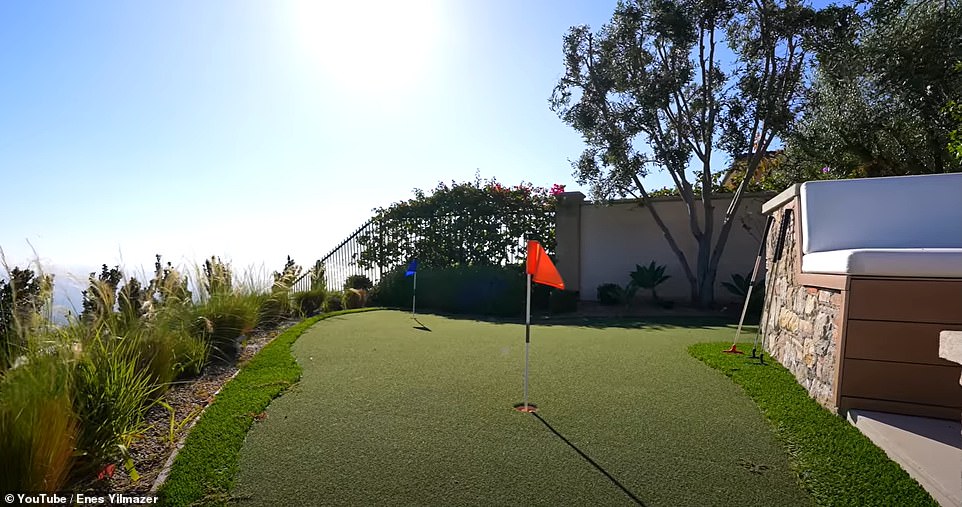 The back terrace has plenty of room for entertaining with a poolside cabana complete with a TV and there's even a putting green for keen golfers.