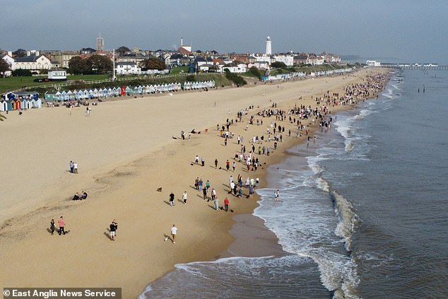 Dachshund owners strolling along Southwold seafront during the world's largest annual gathering for sausage dogs