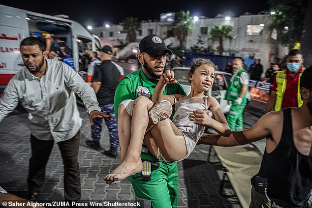 A paramedic holds a crying little girl after she was taken from the scene of the bombing in Gaza on Monday