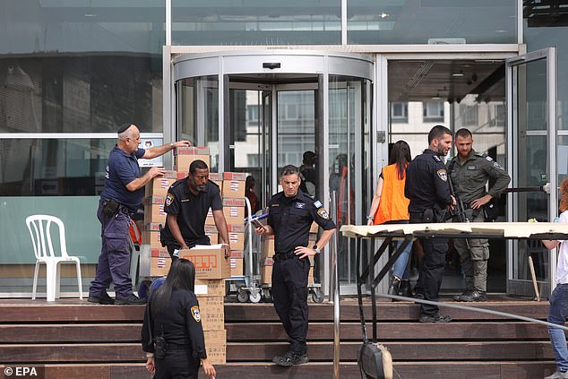 Police officers took the boxes of evidence outside the center