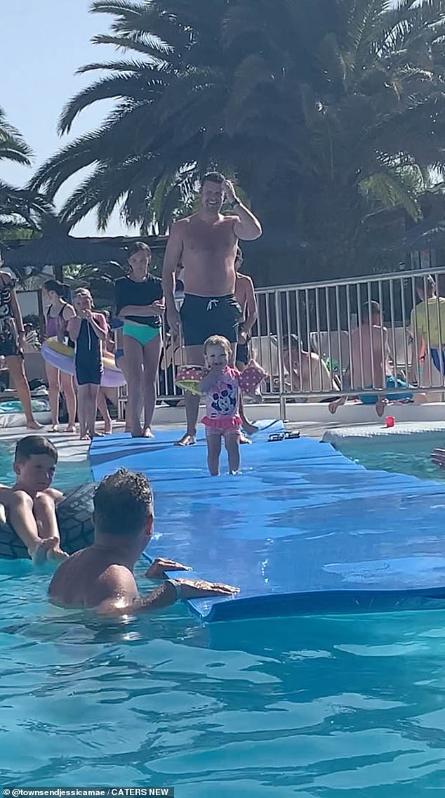 A man in swimming trunks - believed to be Alex's father Jack - prepares the toddler before she embarks on an adventurous foray under the mattress and into the pool