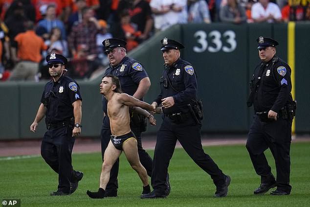 He was handcuffed and led away by police when the match was stopped for the disruption