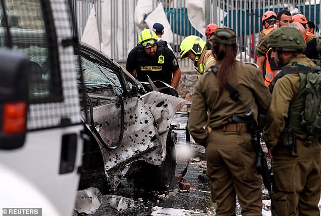 Israeli emergency responders inspect a damaged car after a barrage of rockets fired from the Gaza Strip into the Israeli settlement of Beitar Ilit, in the Israeli-occupied West Bank, on October 9, 2023. 