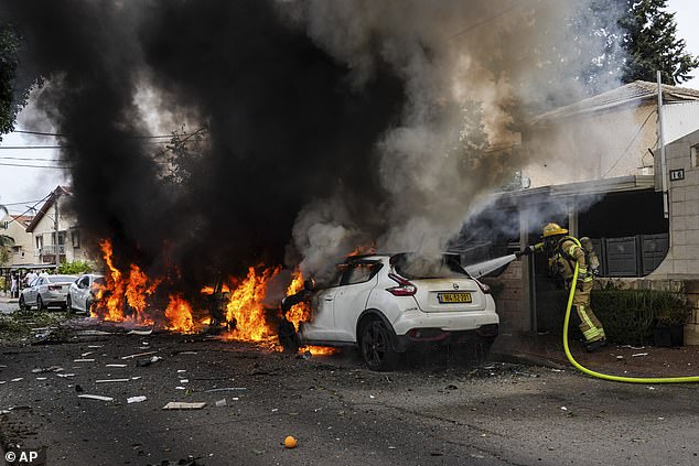 Israeli firefighters put out a fire at a site hit by a rocket fired from the Gaza Strip, in Ashkelon, southern Israel, Monday, October 9, 2023