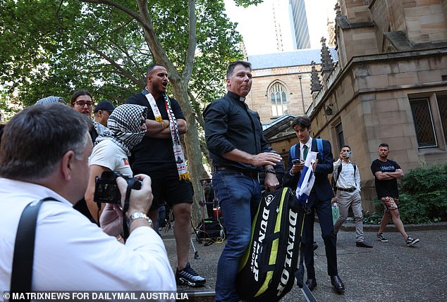 Mr Leach is seen confronting pro-Palestinian supporters after he appeared at the rally with an Israeli flag