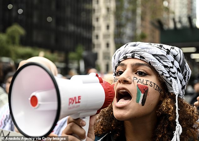 A pro-Palestinian woman shouts in a loud hailer at the tense Monday rally