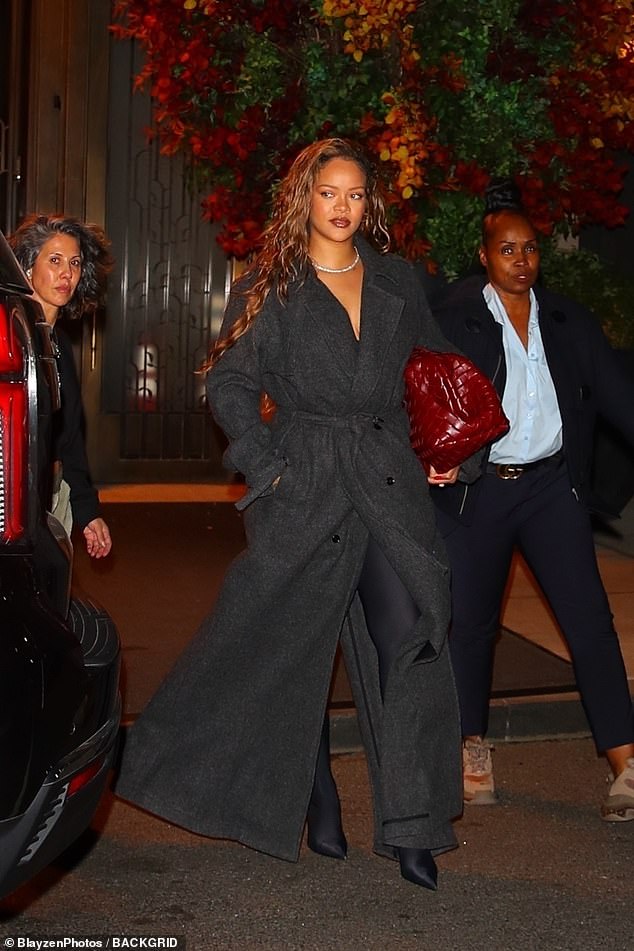 Effortlessly chic: The Fenty Beauty founder accessorized her sophisticated ensemble with a diamond necklace and a large red bag, which she clutched under her left arm