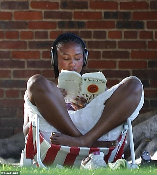 The sociology graduate seems to be making short work of her paperback as the shadows lengthen