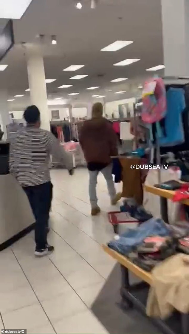 The person recording the clip explains that they are on the first floor of the children's section of the location as the man tries to evade people chasing him wearing nothing but socks.