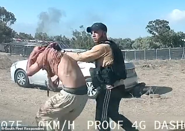 Seconds later he drags his helpless victim by the collar over the frame and away to an unknown destination as another festival goer pretends to be dead behind a car