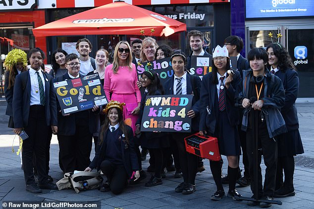 Good reason: The star posed with young people at the celebration of World Mental Health Day in front of Global Studio