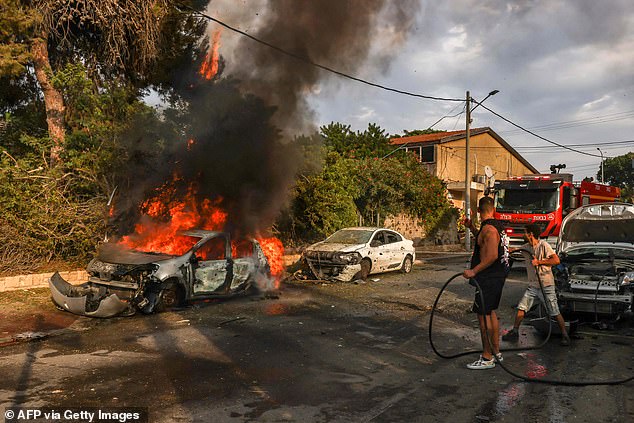 People put out a car fire in Ashkelon, southern Israel, after a rocket attack from Gaza