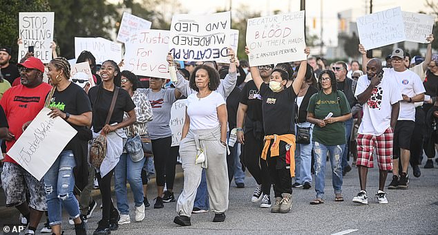 People march along Lee Street in downtown Decatur, Ala., Friday, Oct. 6, 2023, during a protest against the police killing of Steve Perkins a week earlier