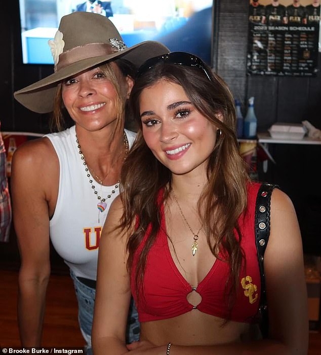 Fit and fabulous: Mum wore a white USC tank top that showed off her toned arms, while her daughter wore a marron USC bra that flashed her tummy