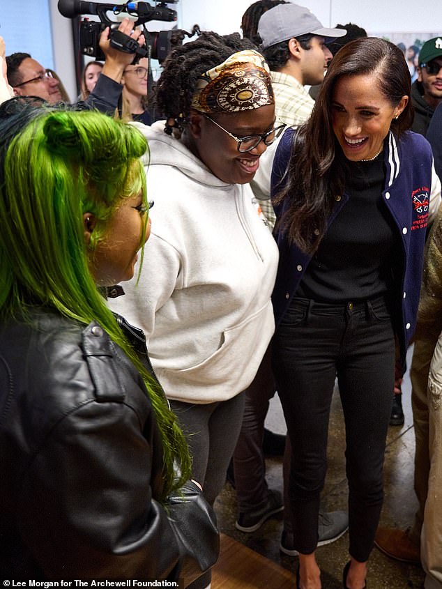 The Duchess wore black skinny jeans, a fitted black top and a pair of heels - along with the letterman jacket she received from a debating team at a UK school in March 2020