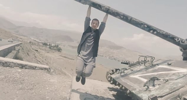 Dangerous tourist.  Miles is pictured hanging from the gun of a Russian tank with his 