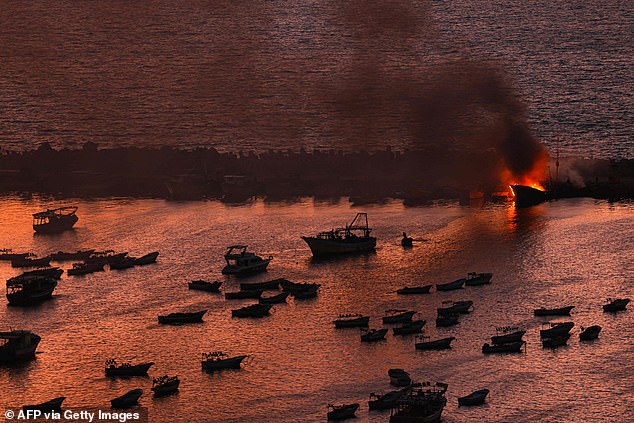 Smoke billows from a boat after an attack by Israel on the port of Gaza City