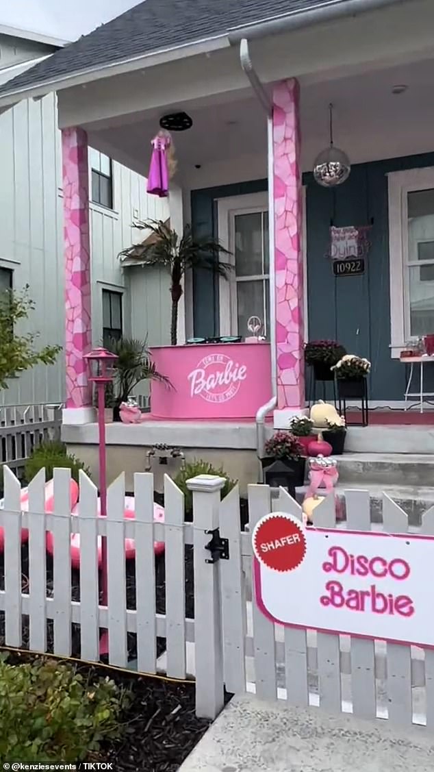 Disco Barbie's house has a DJ controller set up on a pink table that reads 'Barbie' on the front and a matching disco ball hanging from the porch ceiling