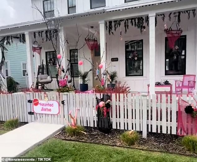 The Haunted Barbie House has an upside down doll in the forest in front, lots of black fabric hanging from the top of the porch and even black mini palm trees at the entrance