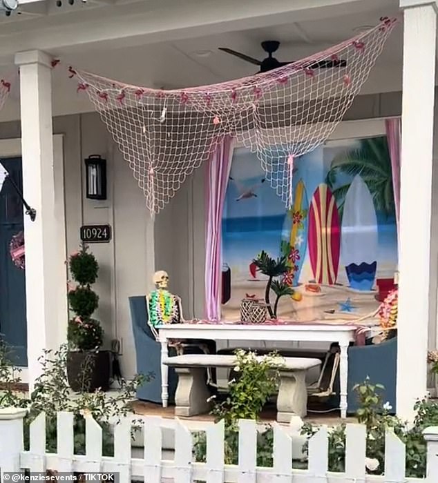 The Beach Barbie house features two skeletons with boas sitting opposite each other in front of a wallpaper of a beach