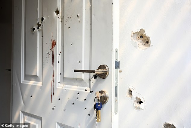 Shots and bloodstains are seen on a door and walls of a house where civilians were killed days earlier in an attack by Hamas on this kibbutz near the border with Gaza on Tuesday