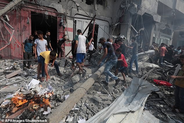 Palestinians are seen collecting rubble in Gaza after Israeli airstrikes