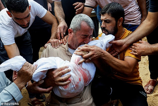 A mourner reacts today as he buries the body of a Palestinian child from al-Agha family, killed in Israeli strikes, in Khan Younis in the southern Gaza Strip.