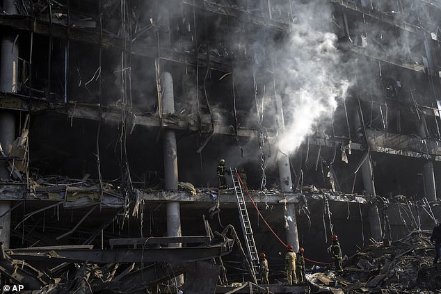 Ukraine 2022: Firefighters try to put out a fire amid the destruction caused after a shopping center was shelled in Kiev, March 21