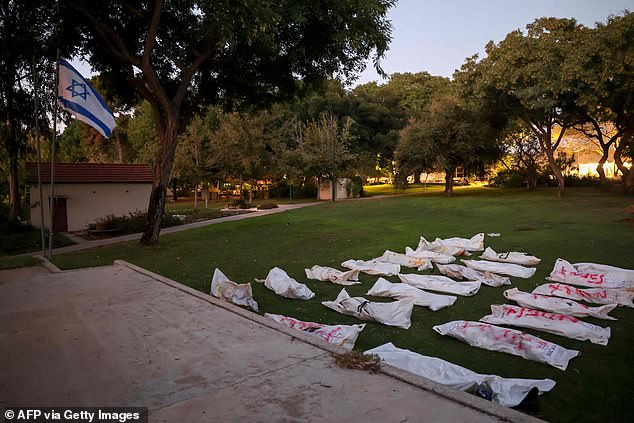 The covered bodies of Israeli victims of the weekend infiltration by Palestinian militants are gathered at Kibbutz Beeri near the Gaza border on October 11, 2023