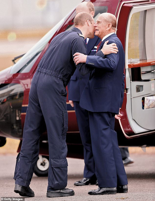 Prince William, Duke of Cambridge kisses Prince Philip, Duke of Edinburgh as he says goodbye after visiting the new East Anglian Air Ambulance base in July 2016