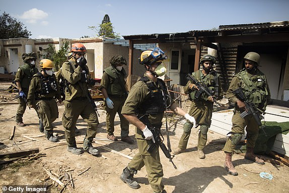 KFAR AZA, ISRAEL - OCTOBER 10: Israeli soldiers patrol near burned and ruined houses after an attack by Palestinian militants on this kibbutz near the border with Gaza on October 10, 2023 in Kfar Gaza, Israel.  Israel has sealed off Gaza and carried out airstrikes in the Palestinian territory after a Hamas attack killed hundreds and took around 100 hostages.  On October 7, the Palestinian militant group Hamas launched a surprise attack on Israel from Gaza by land, sea and air, killing over 700 people and injuring more than 2,000. Israeli soldiers and civilians have also been taken hostage by Hamas and displaced in Gaza.  .  The attack prompted a declaration of war by Israeli Prime Minister Benjamin Netanyahu and continued Israeli retaliatory attacks on Gaza killing hundreds.  (Photo by Amir Levy/Getty Images)