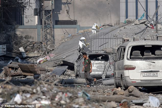 A boy walks past buildings destroyed in Israeli airstrikes in Gaza City on Wednesday