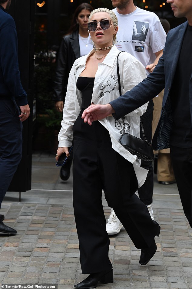 Chic: Guards followed her as she exited the building