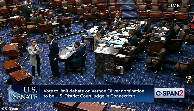 Democratic Senator Amy Klobuchar of Minnesota took advantage of the new dress code to wear black pants, running shoes and a casual jacket;  she speaks with Senator Mitt Romney on the Senate floor Monday night