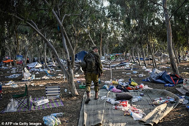 An Israeli soldier searches the music festival grounds on Thursday