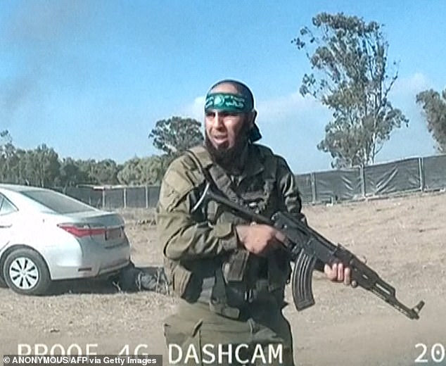 An armed Palestinian militant is seen walking around the Supernova music festival near Kibbutz Reim in the Negev desert in southern Israel.