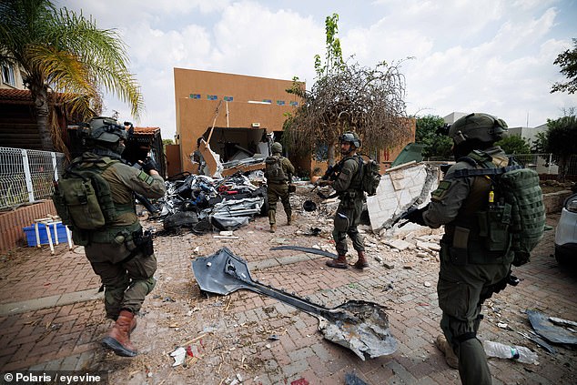 IDF soldiers still look through Kfar Aza days after the massacre began