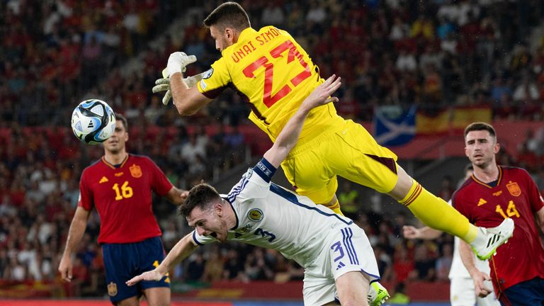 Spaniard Unai Simon collides with Scotland's Andy Robertson 