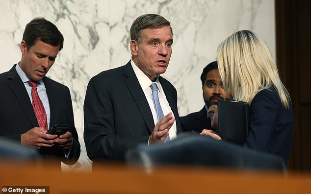 Democratic Senator Mark Warner (center) speaks to staff at the Senate Office Building in September.  Warner is another candidate Romney suggested to run against Biden