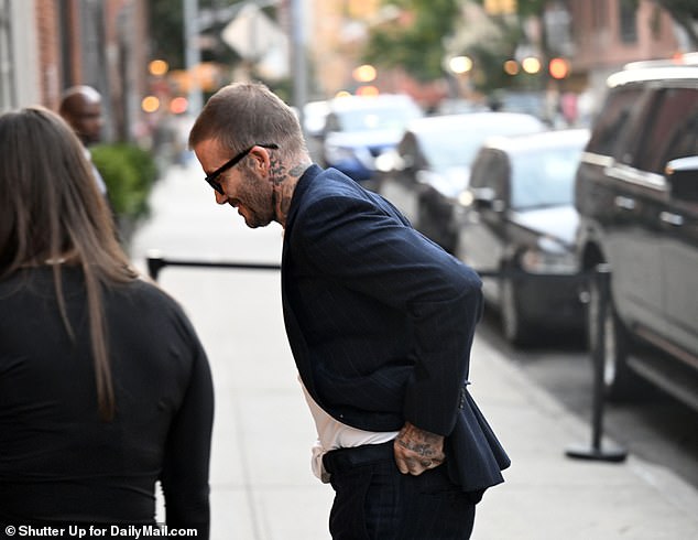 Looking good: He looked dapper in a dark pinstripe suit which he wore with a tie-free white shirt, along with chunky black sunglasses