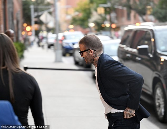 Wardrobe malfunction: However, the athlete-turned-fashion star's shirt appeared to bunch up as he drove to the venue, so he was seen quickly tucking it back into his trousers as he sped along