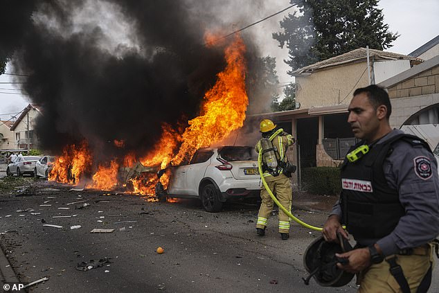 Israeli firefighters put out a fire at the site of a rocket strike from the Gaza Strip in Ashkelon, southern Israel, Monday, Oct. 8, 2023.