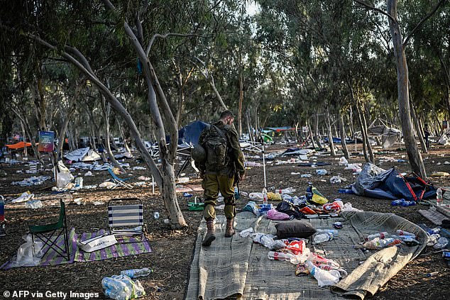 An Israeli soldier surveys the rubble at Kibbutz Beeri, where 270 revelers were killed by militants during the Supernova music festival on October 7.