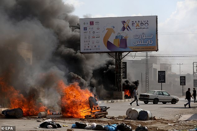 Palestinians seek cover during clashes with Israeli forces in the West Bank city of Nablus, October 13, 2023. According to the Palestinian Ministry of Health, 11 people were killed in the West Bank cities on October 13