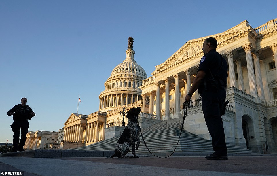 A police officer with a dog patrols the grounds of the US Capitol