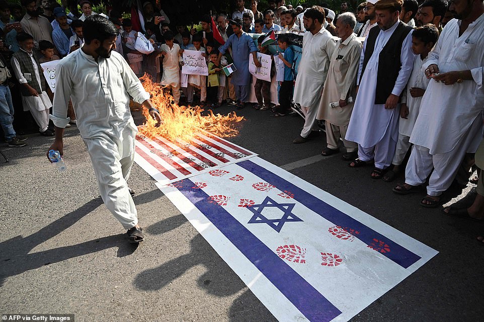 PAKISTAN: Protesters burn the flags of Israel (R) and the US (L) during a rally to express solidarity with the Palestinians, in Islamabad