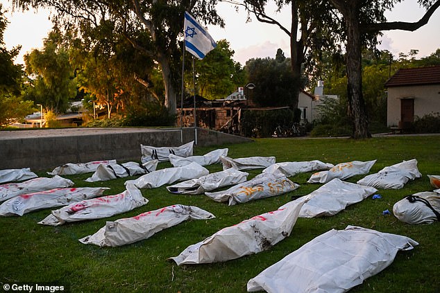 An Israeli flag flies over body bags of more than 20 dead Hamas militants with the word 