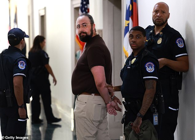 A protester is detained after confronting members of Congress outside a House Republican caucus meeting