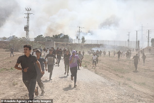 People flee clashes between Palestinian groups and Israeli forces in Gaza City after earlier airstrikes